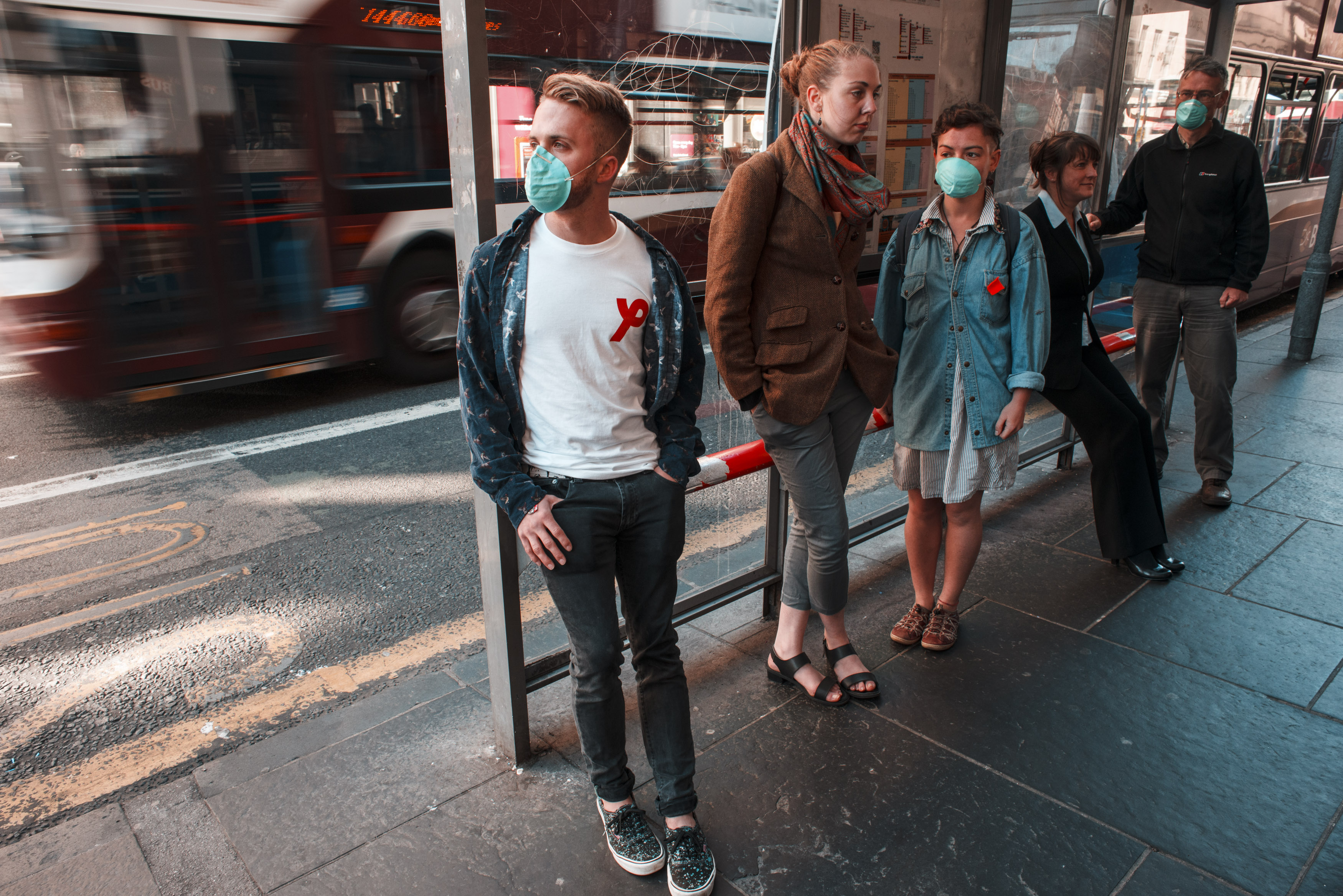 Bus stop with air pollution and people wearing masks