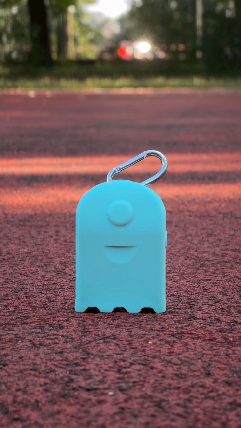 An AirBeam Mini clipped upright on an outdoor running track at golden hour